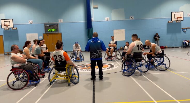 Hampshire Harriers listen to their coach during a training session.