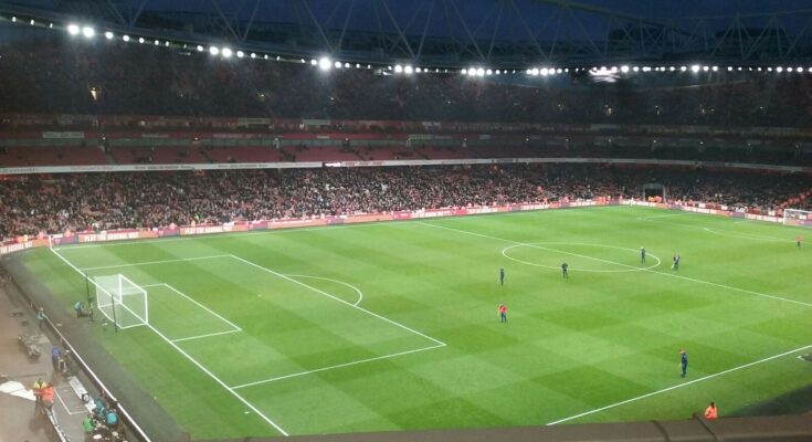 A mostly full night time Emirates Stadium.