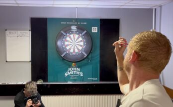 Richard North throwing a dart at a dartboard