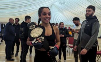 MMA fighter holds belt after victory