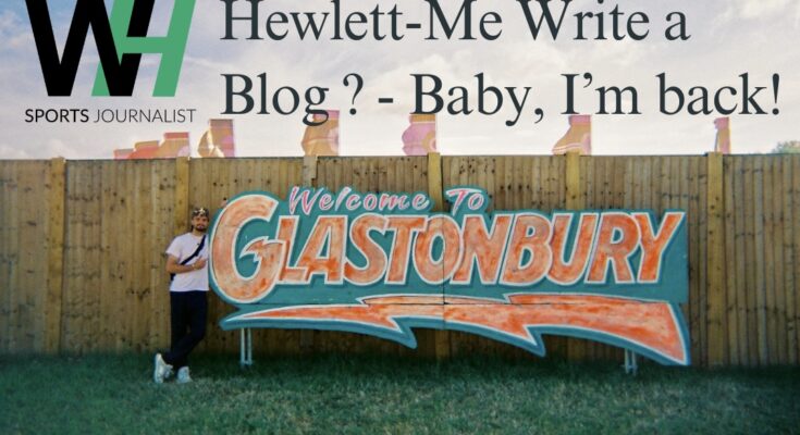 Hewlett-Me Write A Blog? - Baby, I'm back! Will Hewlett stood next to an orange and green 'Glastonbury' sign.