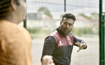 Cricket coach Tanvir Ahmed using his hands to explain a skill to a young player.