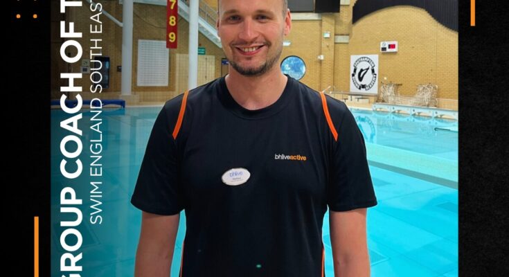 Coach having photo tae for coach of the year in front of a diving pool