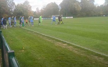 Football players walking out onto the pitch with fans chanting