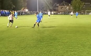 Member of Southampton legends team runs with the ball, under pressure from Brockenhurst defender.