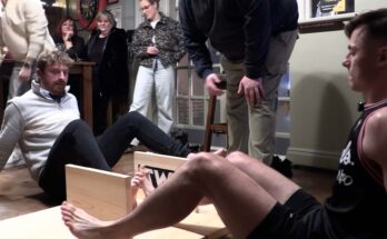 Two people toe wrestling in a pub