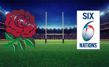 On the background of a rugby pitch, the badge of England's Rugby team lies opposite that of the Six Nations tournament.