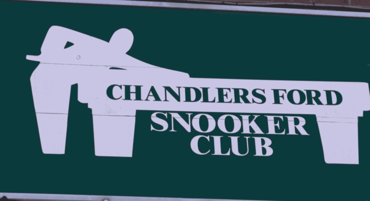 Green snooker club sign on brick wall