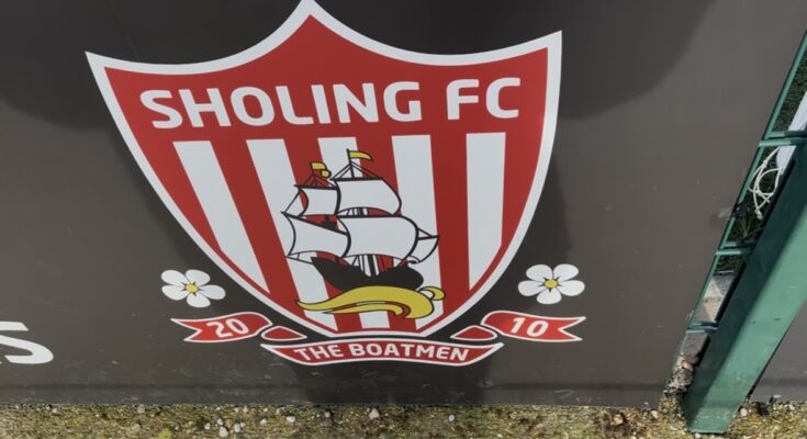 Red and White badge on a black background on a fence