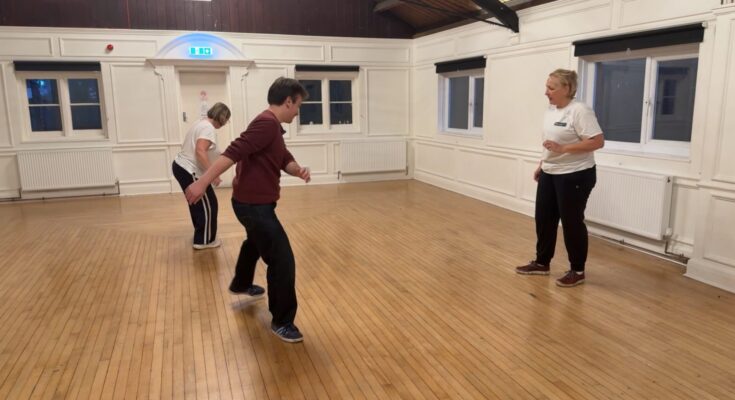 Image of a capoeira training session containing three people.