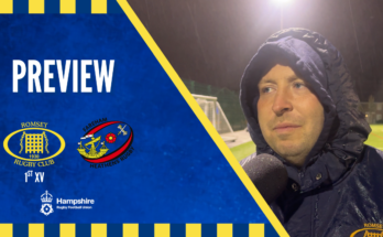 Rugby manager being interviewed with rugby club logos