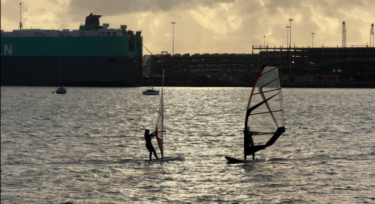 Shot of windsurfers as the sun sets