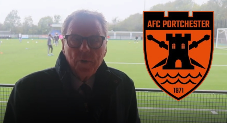 A man with glasses and brown hair looks at a camera with a football pitch in the background and the badge of AFC Portchester to the right