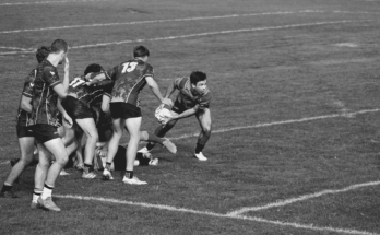 man grabbing rugby ball ready to throw
