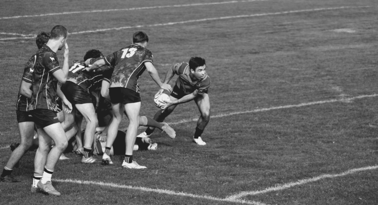 man grabbing rugby ball ready to throw